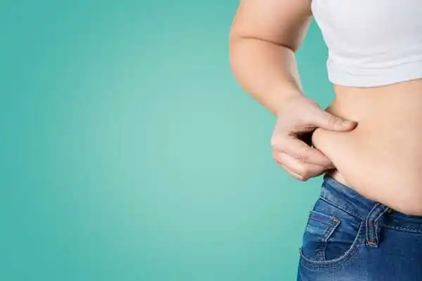 Image of woman pinching her love handles to show weight gain Northfield